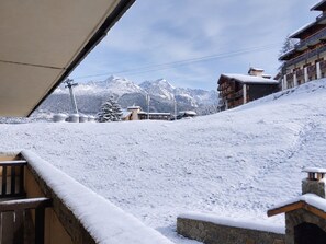 A snow-covered mountain landscape with buildings and a ski lift in the background. - Renovated 2-room apartment, balcony, pets allowed, parking (La Plagne Montchavin Les Coches)