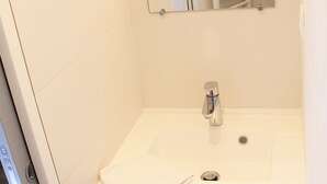 A bathroom with a white sink, a mirror, and a towel rack. - Bright apartment near ski lifts, mountain corner, pets allowed (Briançon)
