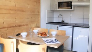 A compact kitchen with wooden walls, a microwave, a sink, and a dishwasher. - Bright apartment near ski lifts, mountain corner, pets allowed (Briançon)
