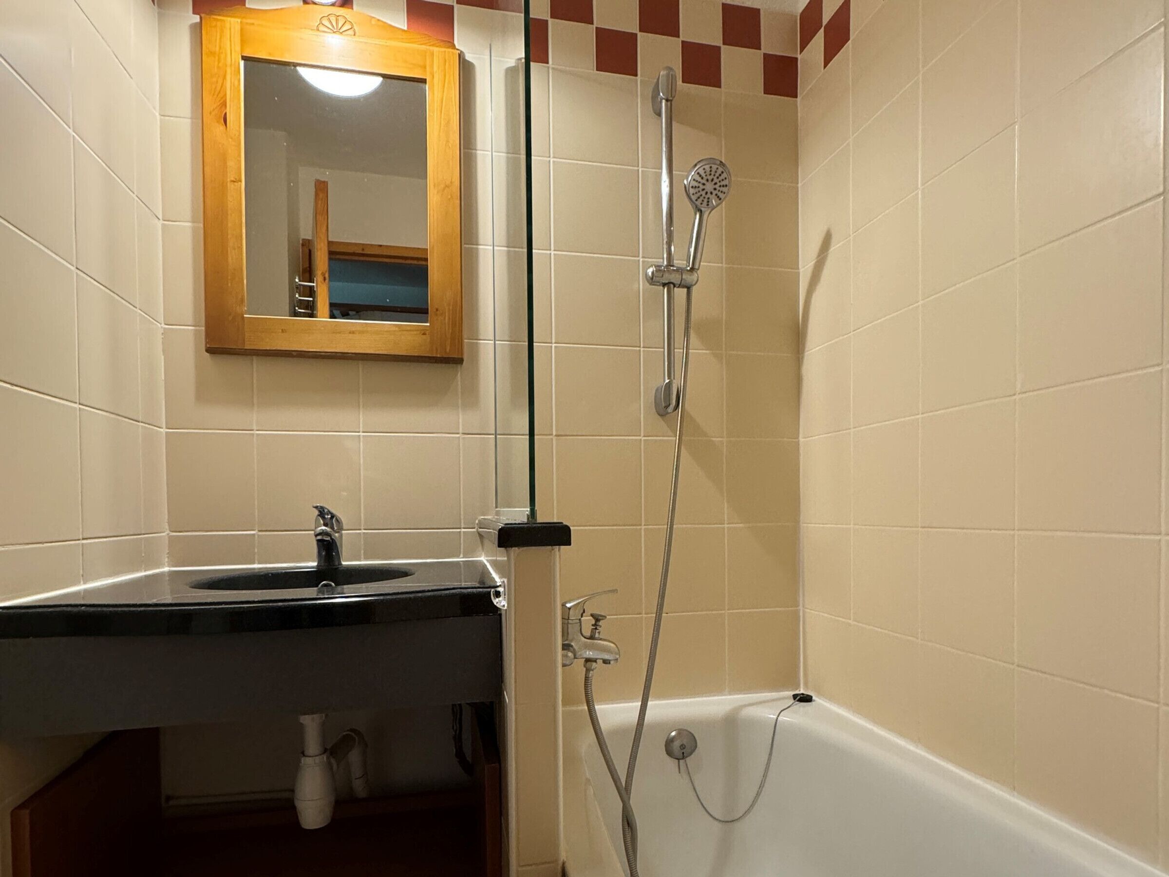 Ein Badezimmer mit Waschbecken, Spiegel und Dusche.