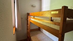 A bunk bed with a wooden frame and a mattress with a pattern.