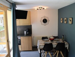Cozy living space with a kitchenette and dining area for four, featuring a coffee maker and microwave.