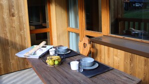 A wooden table with a fruit basket, bowls, and a plate. - Renovated Studio 2019 · Ski-in Ski-out · Balcony (Belle Plagne)