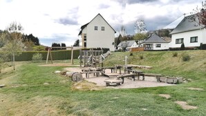 A playground with wooden structures and a sandbox. - Vacation home with garden and terrace, 15 minutes from the Moselle (Blankenrath)