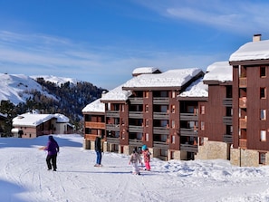 Ein Skigebiet mit Holzhäusern und schneebedeckten Dächern.