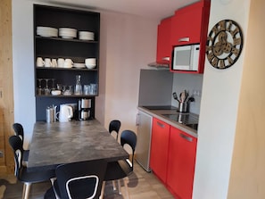 A compact kitchen with a dining table, chairs, a refrigerator, and a microwave. - Comfortable Apartment - Near Slopes - Pets Allowed (La Plagne Montchavin Les Coches)