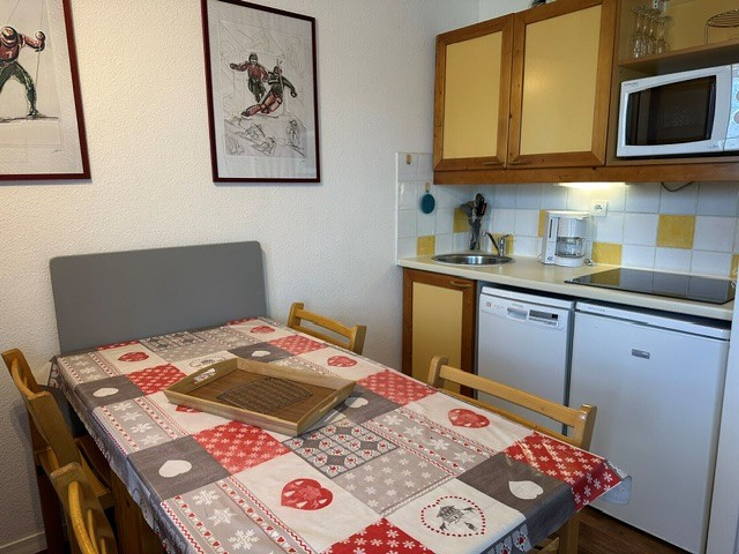 A compact kitchen with wooden cabinets, a microwave, and a dishwasher.