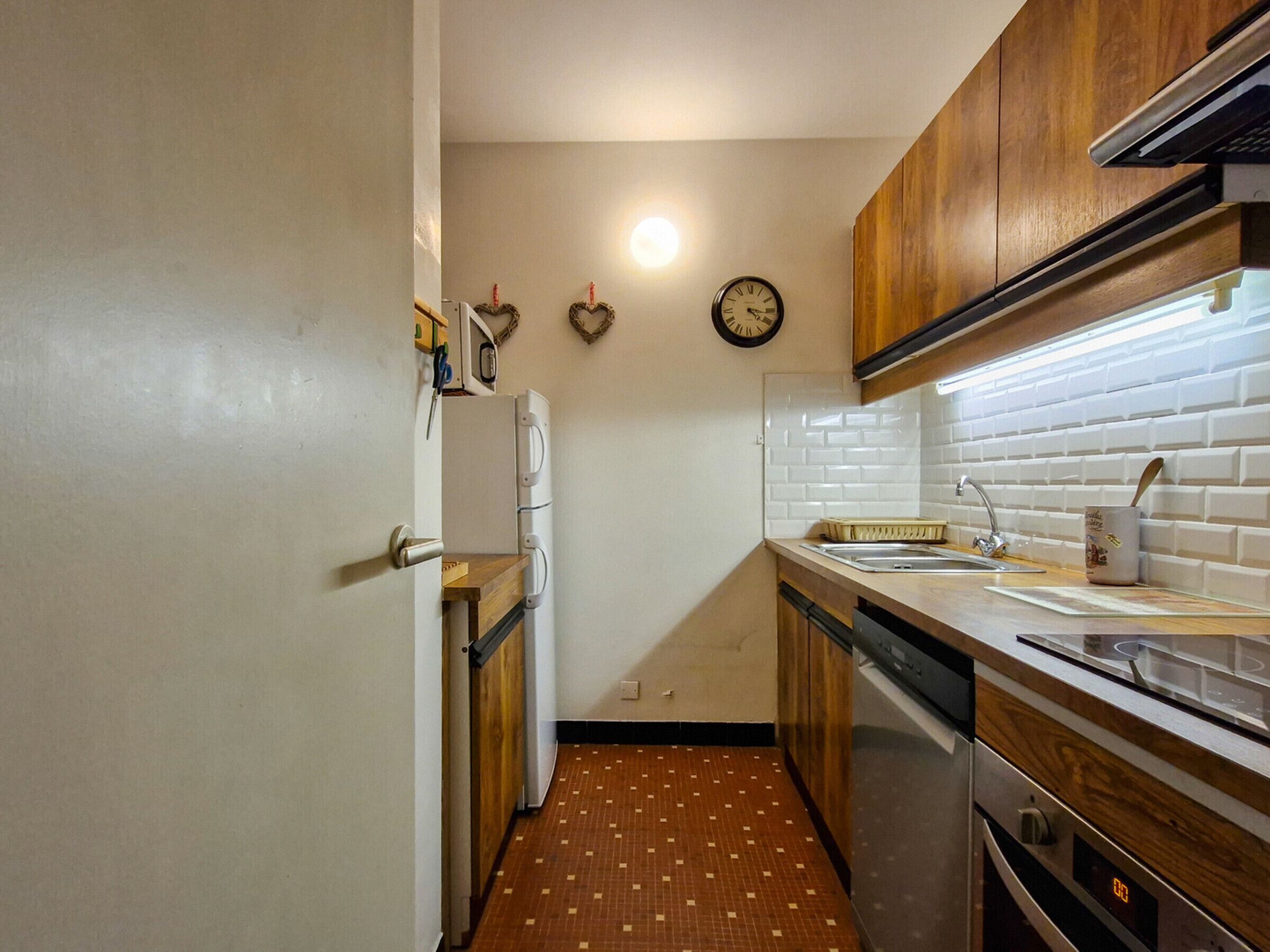 A compact kitchen with a refrigerator, stove, and sink.