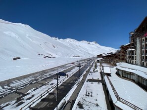 Uma estrada coberta de neve com edifícios à direita.