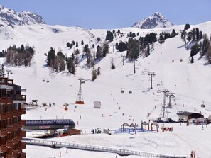 Ein Skigebiet mit Sessellift, Skipisten und einem Gebäude mit der Aufschrift 'ARPETTE'.