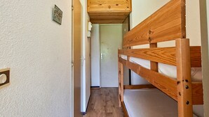 A narrow hallway with a bunk bed on the right and a door at the end. - Comfortable studio with balcony in Flaine center (Flaine)