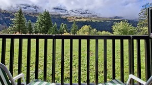 A balcony with a view of a mountainous landscape, including snow-capped peaks and a forested valley. - Comfortable studio with balcony in Flaine center (Flaine)