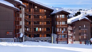 A multi-story hotel with balconies, a stone facade, and a sign indicating it is the Hotel Turquoise. - Apartment with balcony and direct slope access, pets allowed (Belle Plagne)