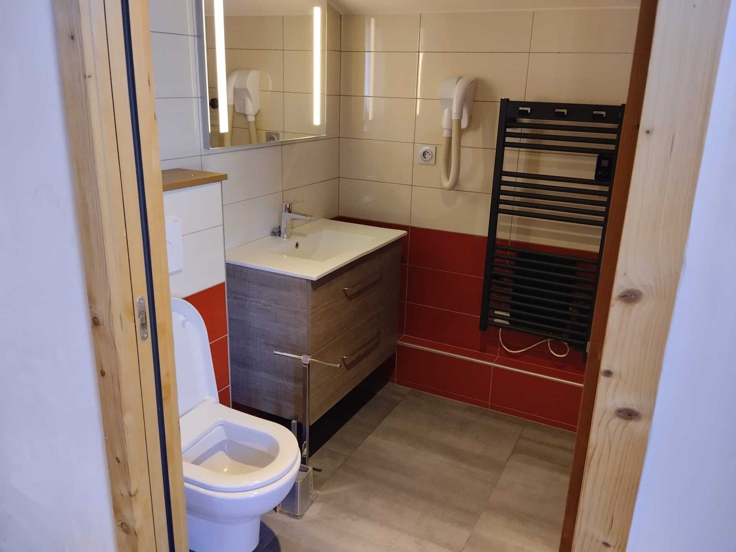 Une petite salle de bain comprenant des toilettes, un lavabo et un porte-serviettes.