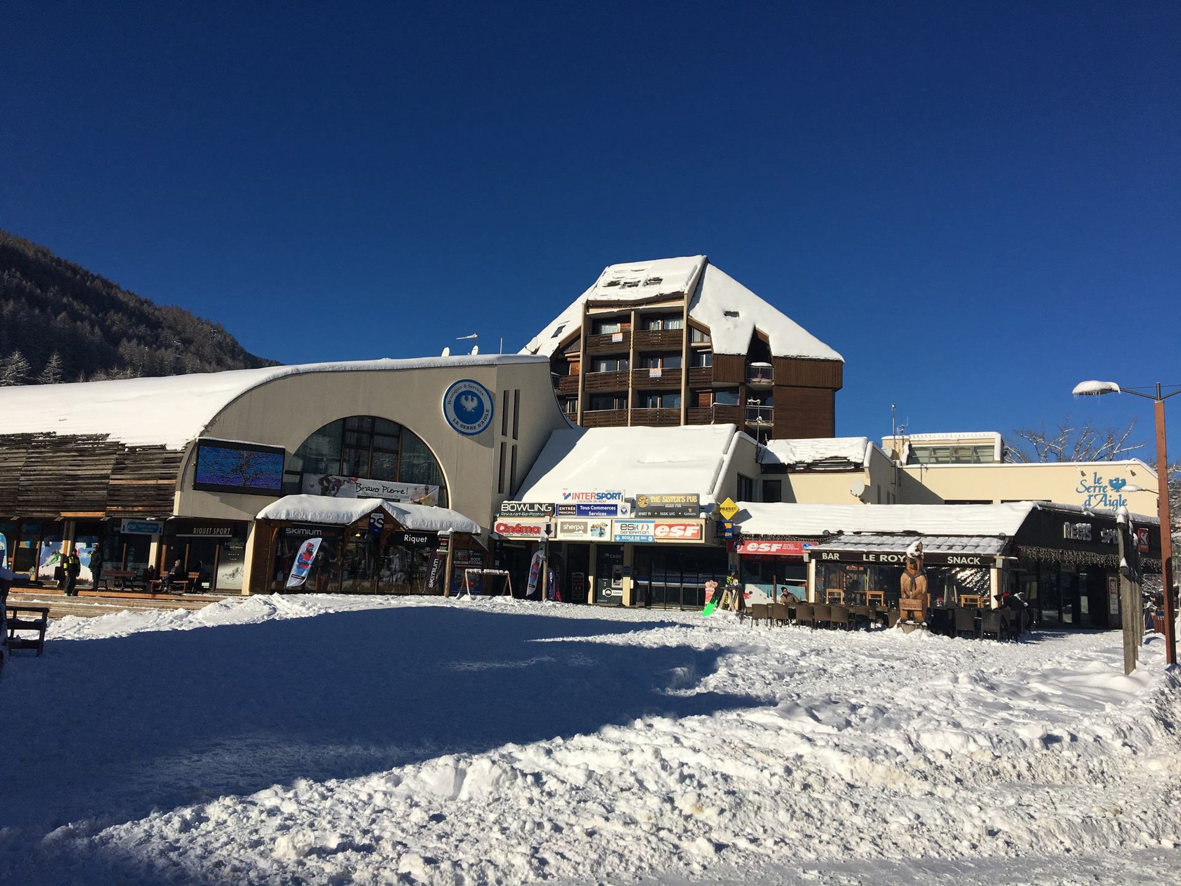 A building with multiple storefronts, including a bowling alley and a bar.