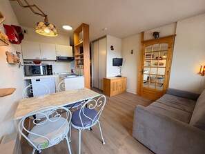 A compact living space with a kitchenette, dining area, and seating.