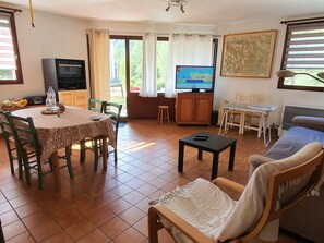 A living room with a dining area, a television, a sofa, and a table with chairs. - Apartment 6 pers, ski access, free shuttle (La Salle-les-Alpes)