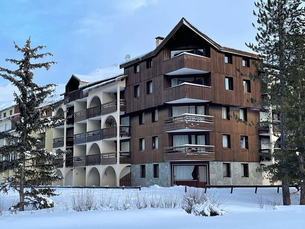 A multi-story hotel with balconies and a stone facade.