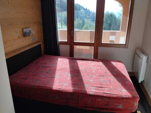 A small room with a single bed, a window, and a radiator.