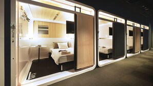 A series of hotel rooms with a modern design, featuring a bed, bedside table, and a television. - First Cabin Nishi Umeda (Osaka)