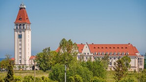 A large building with a clock tower and a red-tiled roof. - Apartamenty Sun & Snow Nowe Hallerowo (Wladyslawowo)