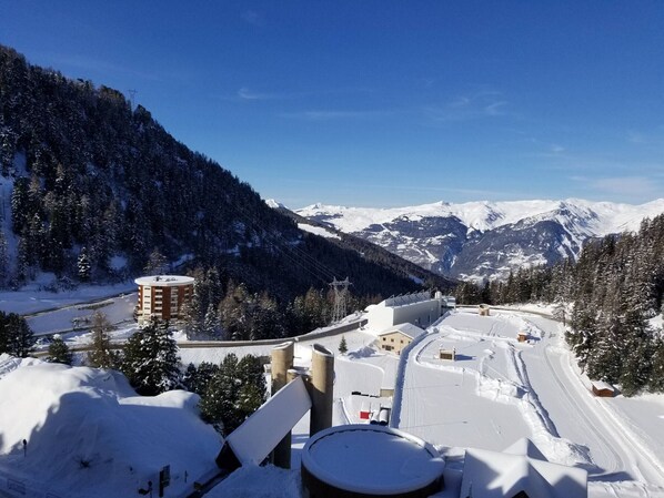 A snow-covered mountain landscape with a road and buildings.