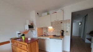 A compact kitchen with a wooden cabinet, a microwave, a coffee maker, and a sink. - Apartment near lifts, free wifi, pets allowed (Briançon)