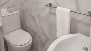 A bathroom with a toilet, a towel rack, and a bathtub. - 7 Eyre Square Lane (Galway)