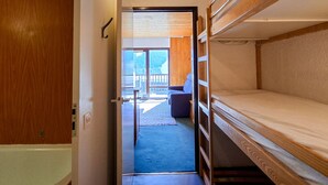 A narrow hallway with a wooden door on the left and a bunk bed on the right. - Comfortable studio in Flaine, balcony, near slopes (Flaine)