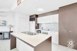 Enjoy cooking in this well-equipped kitchen with a central island, double sink, and ample counter space.