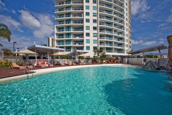 Relax by the inviting pool surrounded by lounge chairs and umbrellas.
