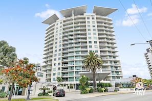 Experience the unique, curved design of this hotel, featuring spacious balconies and a lush lawn with tropical plants.