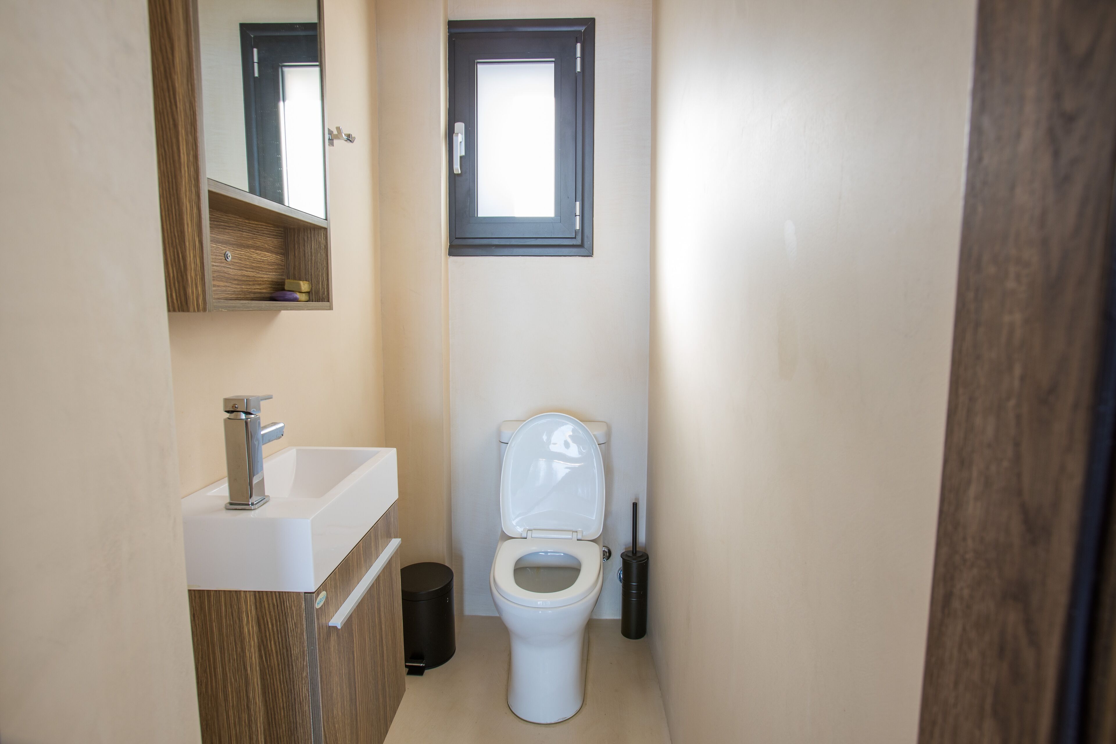 Ein kleines Badezimmer mit Toilette, Waschbecken und Spiegel.
