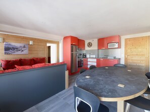A modern kitchen with red cabinets, a built-in oven, and a microwave. - Renovated apt · Close to slopes · Pets allowed (La Plagne Montchavin Les Coches)