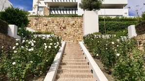 Un edifici modern amb una paret de pedra i unes escales blanques que hi convergeixen.