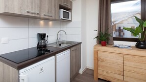 A compact kitchen with a microwave, coffee maker, and dishwasher. - Renovated apartment near slopes with Wifi and pets allowed (Briançon)