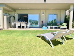 Eine Terrassenanlage im Freien mit Esstisch, Lounge-Stühlen und einer Sitzecke mit Sofa und Couchtisch.