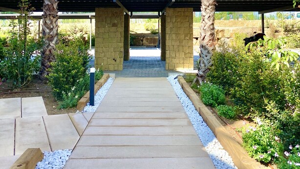 A pathway leading to a covered structure with palm trees on either side. - 54 - Apartment on the cala golf course (La Cala de Mijas)