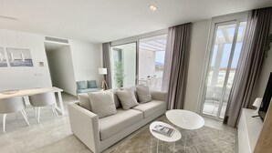 A modern living room with a sofa, a dining table, and a small coffee table. - 55 - Apartment in La Cala de Mijas (La Cala de Mijas)