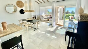 Una sala de estar moderna con comedor, chimenea y vistas al exterior.