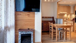 Una cocina moderna con armarios de madera, una estufa empotrada y un comedor con mesa y sillas de madera.