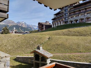 A mountain lodge with a stone oven, a ski lift, and a view of snow-capped mountains. - Renovated apartment near slopes, balcony, pets ok (La Plagne Montchavin Les Coches)