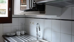 A kitchen with a stainless steel sink, a microwave, and a stove. - Semi-detached duplex chalet - Shuttle to slopes, Free Wifi (La Salle-les-Alpes)