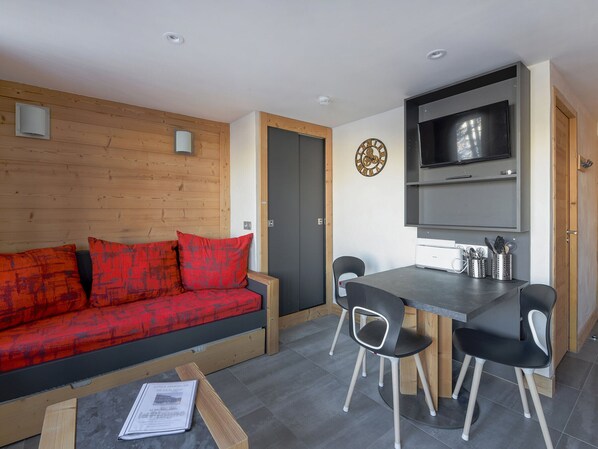 Un espacio habitable compacto con un sofá, una mesa de comedor y sillas.