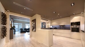 A modern kitchen with a central island, built-in appliances, and a clean, minimalist design. - Maison Privee - Luxurious 2/Bed Apt on Palm Jumeirah (Dubai)