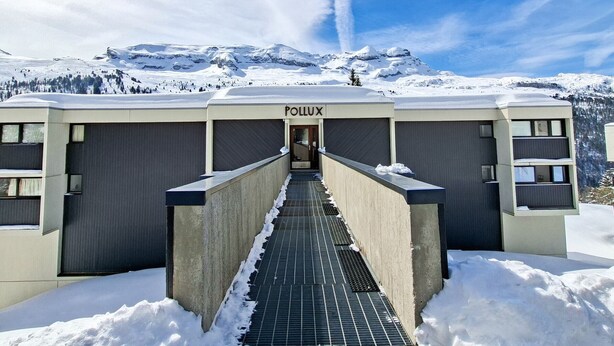 A modern building with a sign 'POLLUX' at the entrance, surrounded by snow and mountains. - Cozy studio in Flaine, south balcony, near slopes (Flaine)