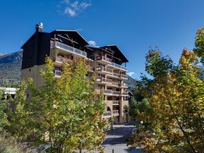 A multi-story hotel with balconies, surrounded by trees and mountains. - Studio at the slopes with Wifi and pets allowed (Briançon)