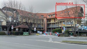 Ein mehrstöckiges Gebäude mit rotem Dach, beschriftet als Apartment A14.
