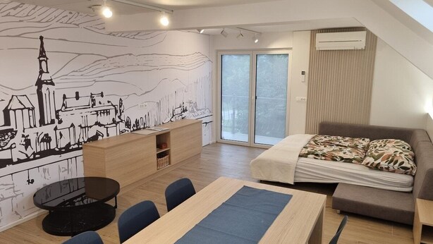 Ein modernes Zimmer mit einem großen Bett, einem Schreibtisch und einem Esstisch.