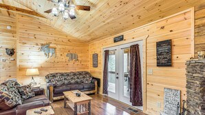 Ein gemütliches Blockhaus-Interieur mit Holzwänden, einer Couch, einem Couchtisch und einem Kamin.